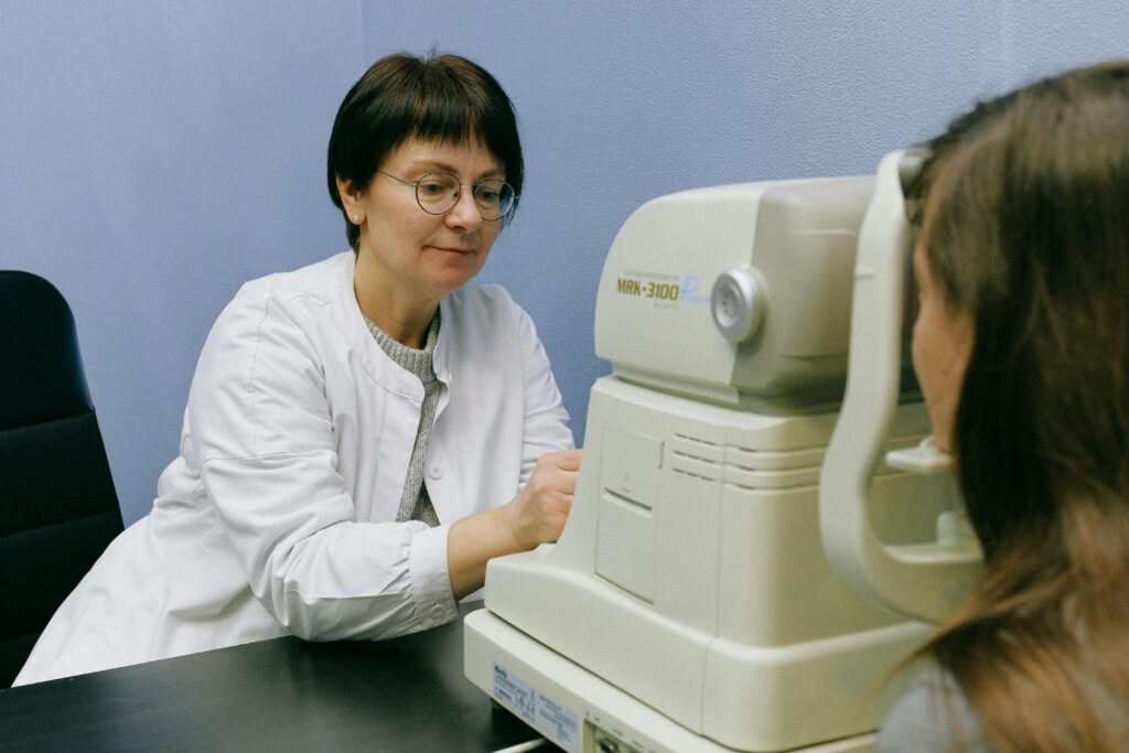 A healthcare professional conducts an eye exam using advanced technology in a clinical setting.